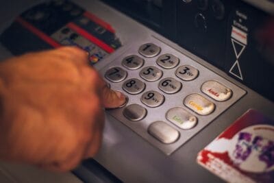 qual a taxa do CDI hoje: pessoa usando caixa eletrônico de banco