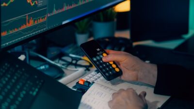 indicadores financeiros: homem fazendo calculos no celular