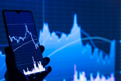 o que ibovespa: gráficos em uma tela de celular e em um telão